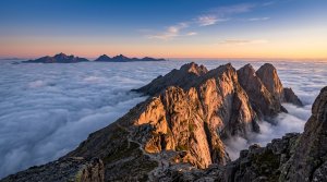 Mountain ridge at sunrise above a sea of clouds